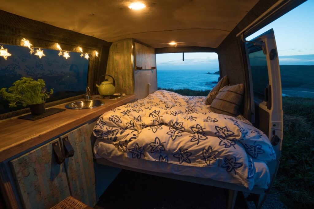 The bed area at night inside this handmade selfbuilt campervan. Hire him at https://www.quirkycampers.com/uk/campervans/devon/exeter-devon/baxter/