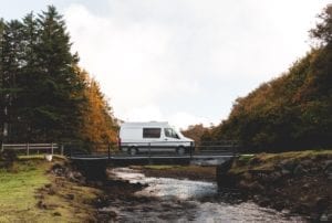 Campervan crossing a bridge over a stream in Skye, Scotland