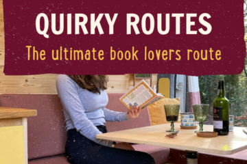 A woman is sitting on a pink couch reading a book with a yellow cover at a wooden table. The table has two green glass goblets, a bottle of wine, and a second book. Above, the text reads "QUIRKY ROUTES: The ultimate book lovers route" in bold white and yellow letters on a burgundy background.