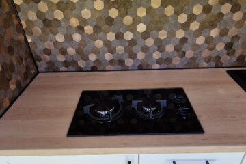 stove top on the counter and white cabinets above