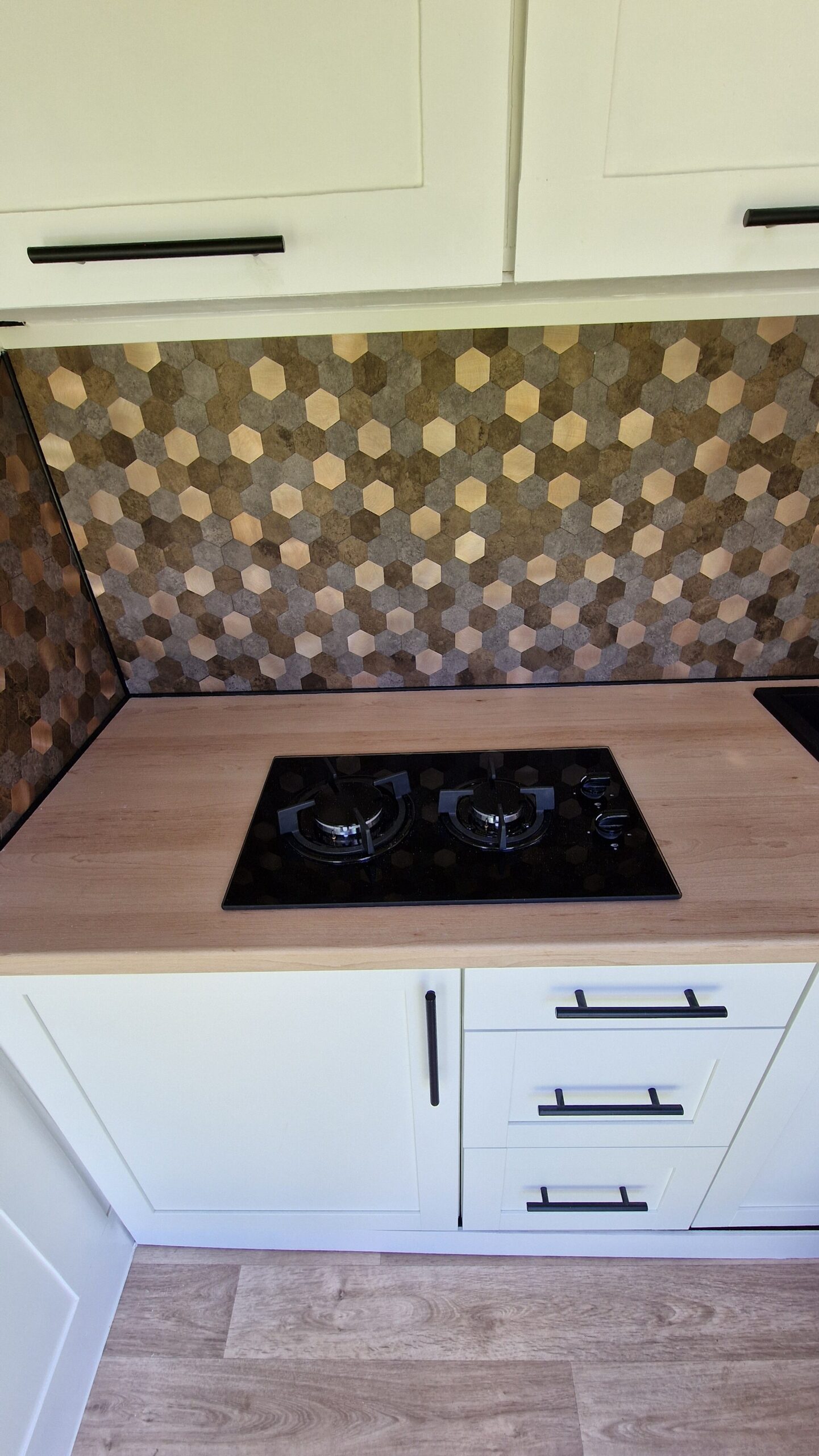 stove top on the counter and white cabinets above